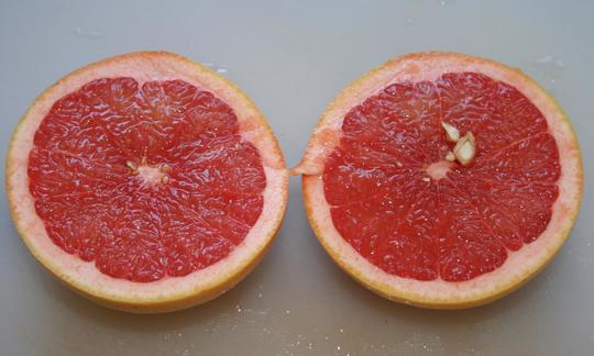 Raw, untreated and halved pink grapefruit (Citrus paradisi)