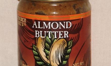 Kaufbare Mandelbutter in Glasbehälter, neutrale Teilansicht ohne Hersteller. Kaufbare Mandelbutter in Glasbehälter, neutrale Teilansicht ohne Hersteller.