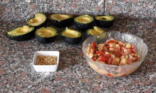 Sullo sfondo, gli avocado si dividevano a metà, nella ciotola, il ripieno pronto, accanto ai pinoli