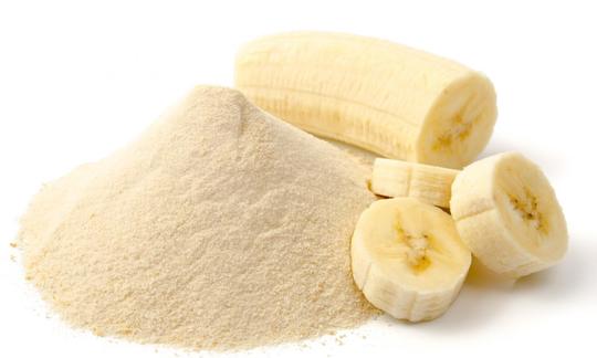 Bananenpulver bzw. Bananen-Fruchtpulver aufgehäuft, rechts daneben Bananenstückchen.