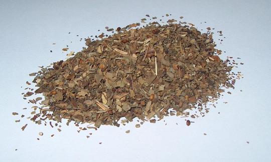 Dried basil piled up on a light-coloured base.