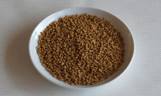 Semillas de alholva: las semillas de alholva son legumbres con forma de cápsula, que además sirven como especia. Semillas de alholva en un cuenco blanco. Estas semillas se usan como especia.