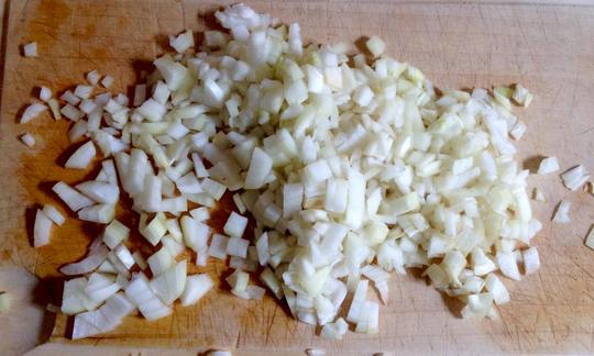 Chopped onion pieces for the potato and bean stew with dill