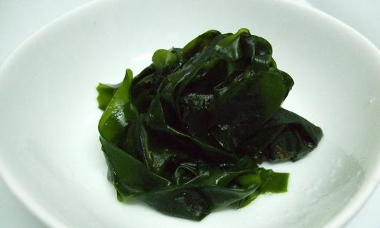 Gekochte Wakame (Undaria spp.) in einer weissen Schüssel Gekochte Wakame (Undaria spp.) in einer weissen Schüssel