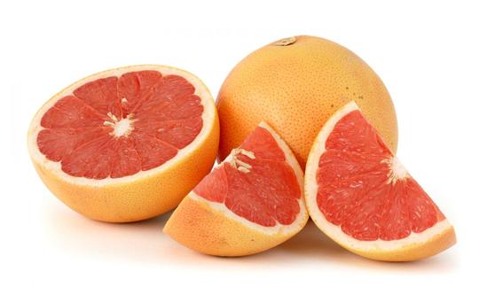 One sliced and one whole grapefruit with red pulp. One sliced and one whole grapefruit with red pulp.