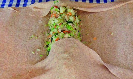 Rolling up the vegetables in the strudel dough for Vegetable Strudel with Frankfurt Green Sauce