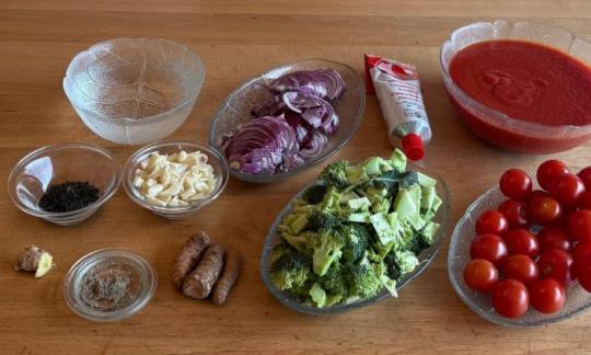 Erb-Lycopin-Suppe, mis-en-place mit den elf Zutaten auf Holztisch.