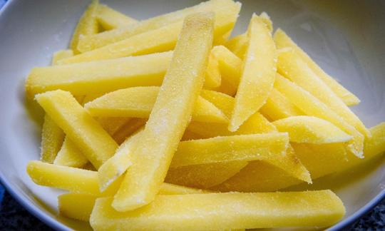Tiras de patata preparadas para la receta de «patatas al horno casera y bajas en grasa».