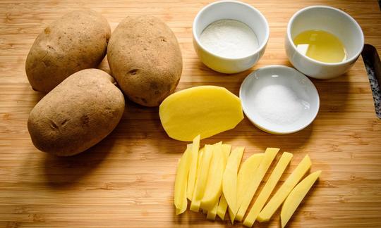 Ingredientes de la receta «patatas al horno caseras y bajas en grasa» en la mesa.