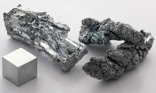 Zinc, 99.955% puro, izquierda: una pieza cristalina, derecha: sublimada - dendrítica (ramificada).