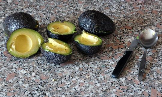 Dimezzato e tritato di avocado per "avocado ripieno di pomodoro, banana e pinoli".