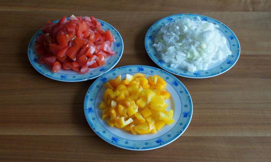 Peperoni, cipolle e pomodori tagliati per preparare "Cile con fagioli da trasportare".