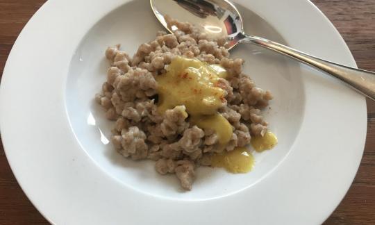 Im Teller angerichtete "Vegane Spätzle mit Dinkelvollkorn und Leinsamen" mit veganer Käsesauce.