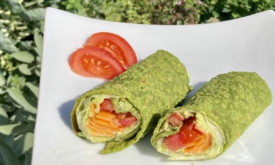 Recipe picture of the "Spinach and chickpea wraps with raw vegetable filling" on a white plate.