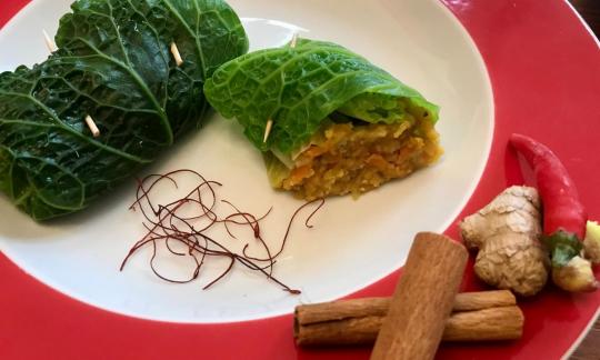Ready-made "Savoy cabbage rolls with red lentils, carrots and ginger", on a white plate.