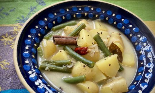 Imagen de la receta "Sopa india de patatas con judías verdes", servida en un plato.