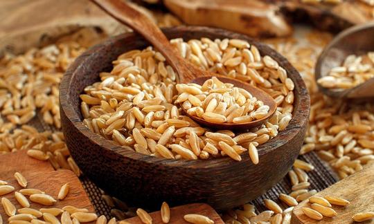 Trigo Kamut o Khorasan, Triticum turgidum subsp. Turanicum todavía crudo en un tazón de madera. Trigo Kamut o Khorasan, Triticum turgidum subsp. Turanicum todavía crudo en un tazón de madera.