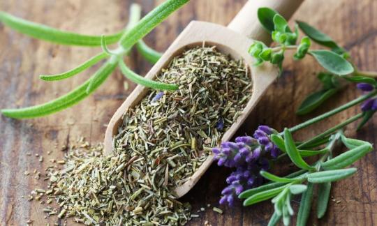 Hierbas de Provenza en un cucharón de madera con partes de plantas al lado. Hierbas de Provenza en un cucharón de madera con partes de plantas al lado.