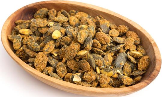 Roasted pumpkin seeds in an oval-shaped wooden bowl. Roasted pumpkin seeds in an oval-shaped wooden bowl.