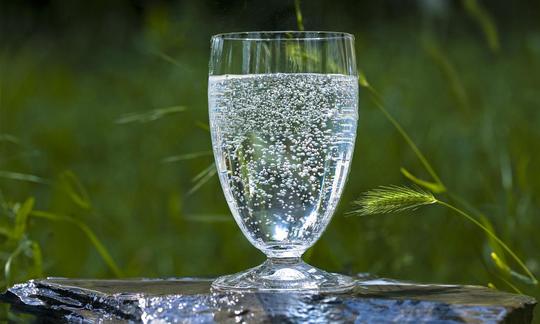 Mineralwasser in Trinkglas auf Stein. Mineralwasser in Trinkglas auf Stein.