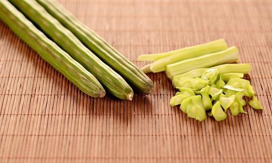 Vainas de moringa sin procesar junto a algunas semillas y otras vainas peladas. Vainas de moringa sin procesar junto a algunas semillas y otras vainas peladas.