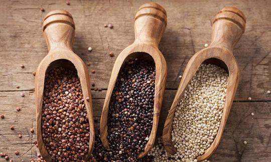 Quinoa, grezza: tre misurini di legno con tre diverse varietà di quinoa.
