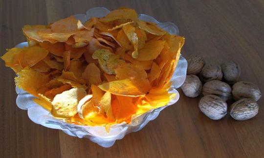 Süsskartoffel-Chips roh. Vergleich der Ausbeute bei 500 g und Baumnüsse als Grössenvergleich.