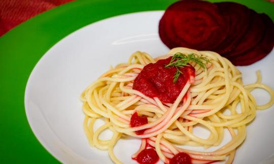 Ready-made "beetroot pasta sauce" with spaghetti and beetroot slices on a white plate.