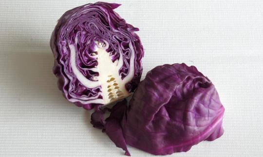 Halved red cabbage (Brassica oleracea) on a light surface. Halved red cabbage (Brassica oleracea) on a light surface.