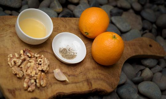 Ингредиенты для "Соуса винегрет без масла с апельсиновым соком и орехами" на разделочной доске.