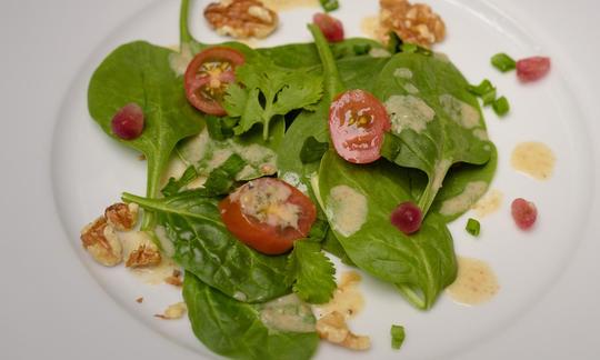 Mit "Ölfreiem Salatdressing mit Walnüssen und Orangensaft" angerichteter Salat auf einem Teller.