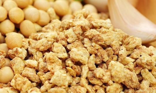 Sojagranulat Nahaufnahme, oben Sojabohnen, rechts Knoblauchzehe zum Grössenvergleich. Sojagranulat Nahaufnahme, oben Sojabohnen, rechts Knoblauchzehe zum Grössenvergleich.