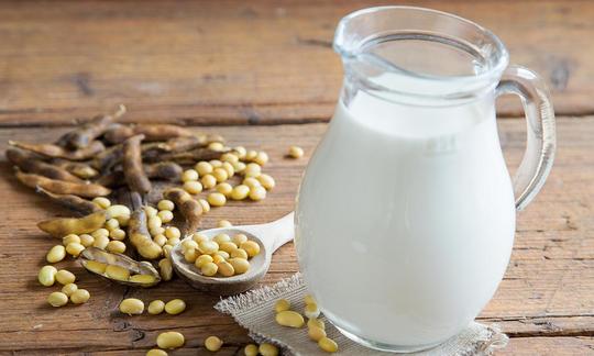 Sojamilch, original oder Vanille, in einem Glaskrug, daneben Sojabohnen offen und in Hülse. Sojamilch, original oder Vanille, in einem Glaskrug, daneben Sojabohnen offen und in Hülse.