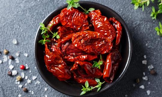 Mitades de tomate secado al sol con sal y especias con cáscara - Solanum lycopersicum. Mitades de tomate secado al sol con sal y especias con cáscara - Solanum lycopersicum.