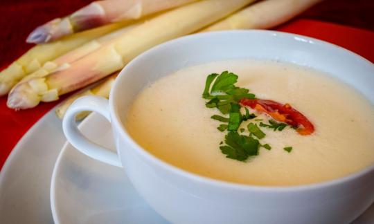 «Crema de espárragos ligera y crudivegana con tomates cherry y perejil», con espárragos blancos.