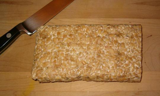 Immagine di tempeh pubblicata dal fotografo e utente "Cdc" su Wikipedia. Immagine di tempeh pubblicata dal fotografo e utente "Cdc" su Wikipedia.