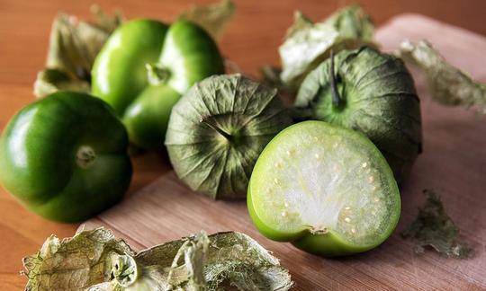Tomatillo, crudo - Physalis philadelphica: con e senza sepali, un frutto tagliato a metà. Tomatillo, crudo - Physalis philadelphica: con e senza sepali, un frutto tagliato a metà.