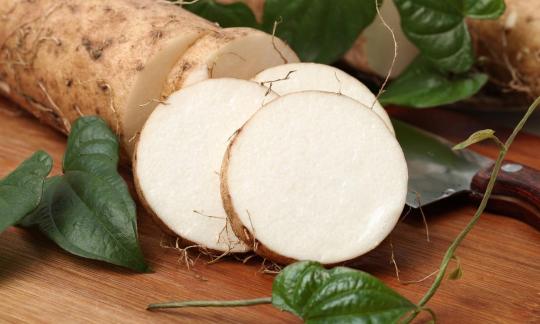 Свежая нарезанная диоскорея в окружении листьев и диоскореи. Свежая нарезанная диоскорея в окружении листьев и диоскореи.