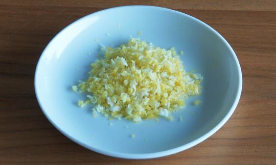 Fein geraspelte Zitronenschale in einer Schale: Zitronenschale unterstützt die Verdauung.