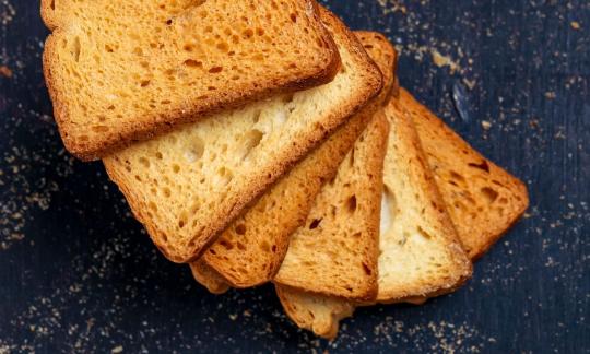 Веганские сухари, запеченные разными способами на темном фоне. Веганские сухари, запеченные разными способами на темном фоне.