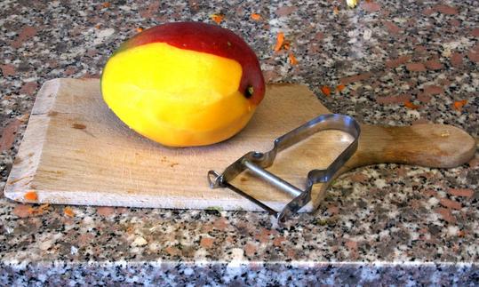 Очистите манго для «Салата Батавия с овощами и манго с ореховой заправкой из чиа».