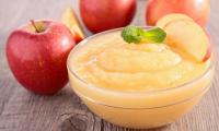 Organic applesauce, unsweetened (apple compote, apple pulp) in glass bowl.