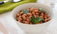 Organic cowpeas, cooked and served in a white bowl.