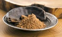 Carob: Carob legume (carob, carube) and carob powder in a plate.