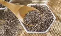 Dried chia seeds in a hexagonal bowl with awooden spoon (Salvia hispanica)