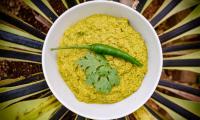 Homemade Laksa curry paste with turmeric and ginger (separate recipe) in white bowl.