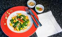 Приготовленный "Азиатский салат из манго и шпината" выложенный на тарелке