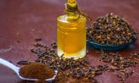 Гвоздика, молотая - Syzygium aromaticum - в ложке, справа от неё сушёная гвоздика и масло..