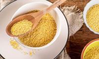 Millet, dry ( Panicum miliaceum L.), in three small ceramic bowls.