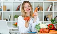 Porträt einer Ernährungsberaterin, die frisches Gemüse für den rohen Gebrauch zeigt.